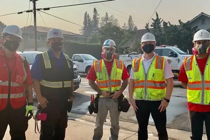 Five crew members in PPE and vests posed on street, Dry 1 Out Restoration and Construction